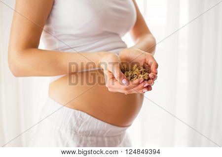 Pregnant woman holding nuts in her palms