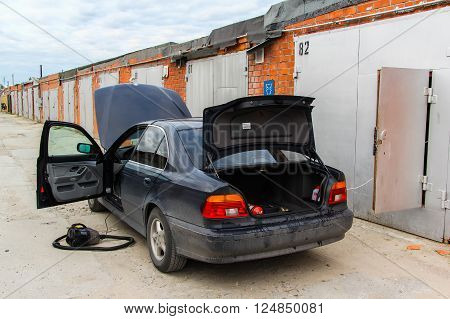 NOVYY URENGOY, RUSSIA - JUNE 26, 2015: Motor car BMW E39 520i is washed and cleaned near the garage.
