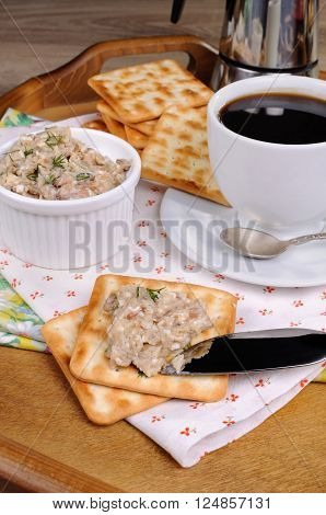 Appetizer of fish paste (forshmak) on a cracker with a cup of coffee