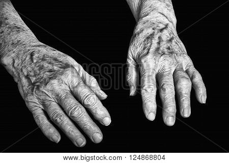 Old hands of woman on a black background