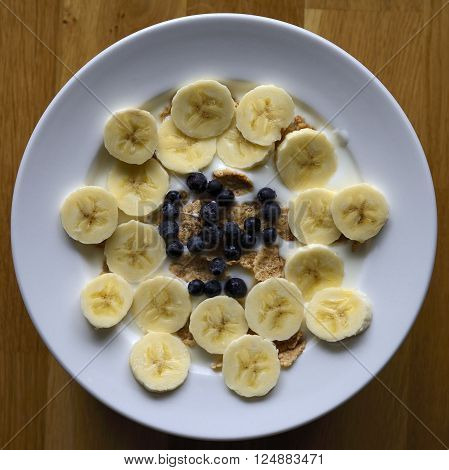 Breakfast cereal with fruit on a wood background