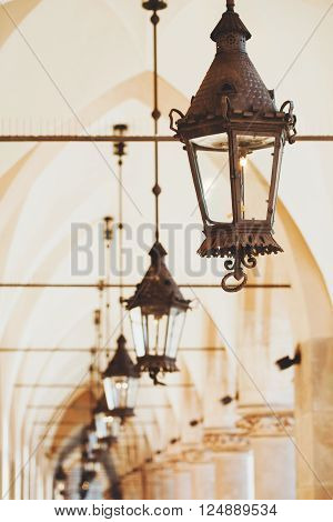 Row of antique lanterns in the old city of Krakow, Poland, in Sukiennice, in the arch.