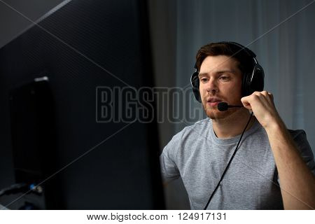 technology, gaming, entertainment, let's play and people concept - young man in headset with pc computer playing game at home and streaming playthrough or walkthrough video