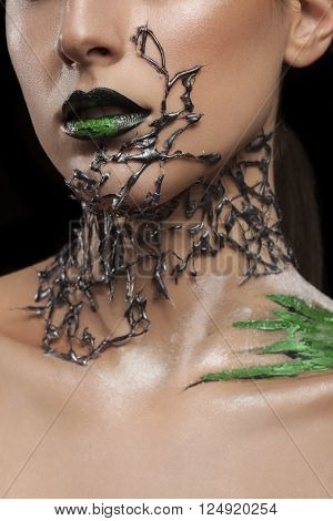 Girl with black fashion mesh arround neck and green make up on black lips. Fashion on stage make up. Artistic make up. Studio