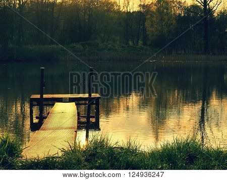 Old small water gate in pond, reflection in water