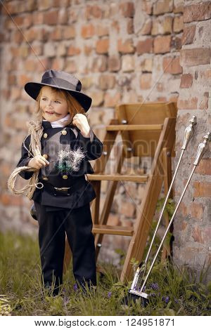 Girl as a chimney sweep against brick wall.