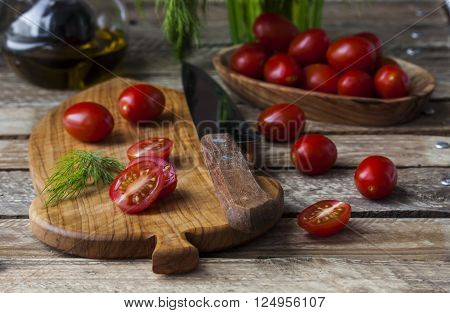 fresh juicy and tasty cherry tomatoes and dill on cutting board