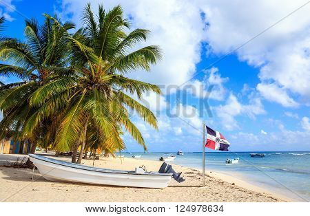 Beautiful caribbean beach and Dominican Republic flag