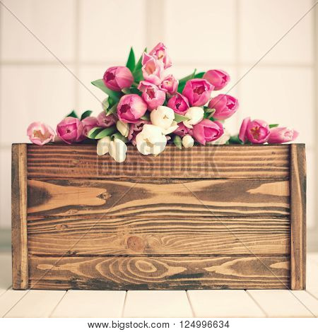 Pink and white tulips over a wood crate
