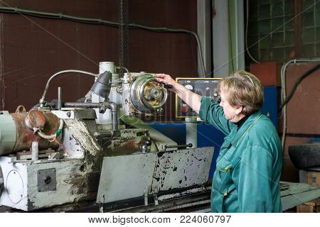 LIPETSK, RUSSIA - JUNE 15, 2017: Lipetsk Machine Tool Plant. A woman works on an internal grinding machine. Stage of metal finishing of parts.