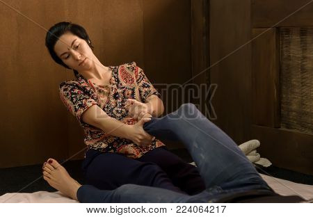 Foot massage in thai studio. Professional therapist giving traditional Thai massage.