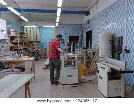 ST. PETERSBURG, RUSSIA - AUGUST 8, 2017: Worker making harp in Resonance Harps enterprise. The company revives the production of harps of the Lunacharsky factory founded in 1947