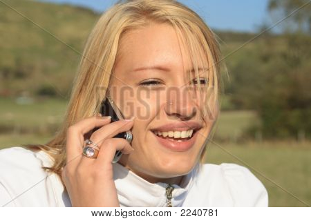 Junge Frau lachend auf einem Mobiltelefon