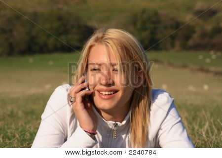 Junge Frau auf ihr Handy In einem Feld