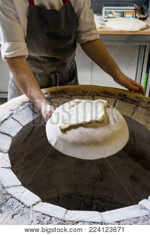 Chef making khachapuri in tandoor. Traditional Georgian starchy food meal