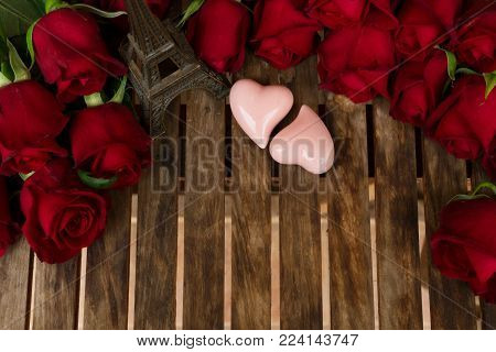 Red Fresh Roses With Two Pink Hearts And Eiffel Tower On Wooden Table