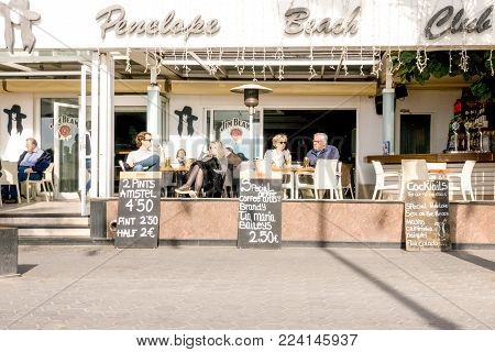 Benidorm, Spain - January 14, 2018: Tourists sitting in a sidewalk cafe in Levante beach area of Benidorm, Spain.