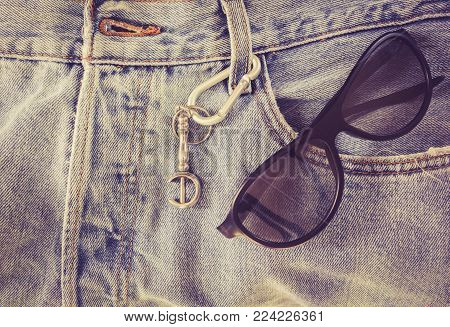 Sunglasses On Jean Pants On A Background