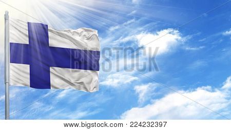 Flag of Finland on flagpole against the blue sky.