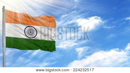 Flag of India on flagpole against the blue sky.