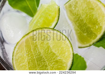 Slices Of Lime With Ice On Wooden Table