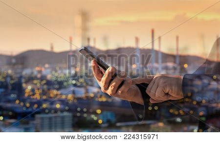 Double Exposure Of Businessman Working With Smart Phone Checking Oil Refinery Industry Plant In Twil