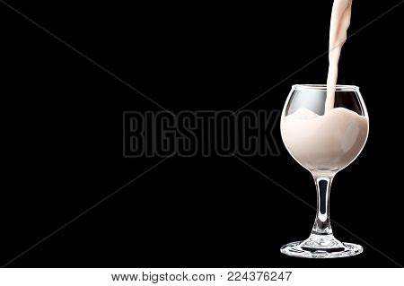 Shot glass filled with liquor isolated on black background. Place for your text.