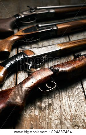 ollection of hunting rifles. Rifles, shotguns on wooden table background, Hunting guns close-up