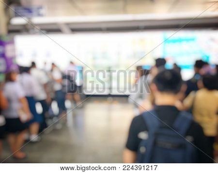 blurred image of people line up waiting for electric sky train station, railroad transportation for passenger in city, urban lifestyle. (BTS : sky train) in Thailand.