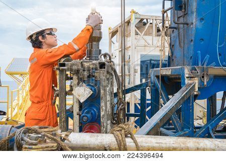 Offshore oil rig worker prepare tool and equipment for perforation oil and gas well at wellhead remote platform.