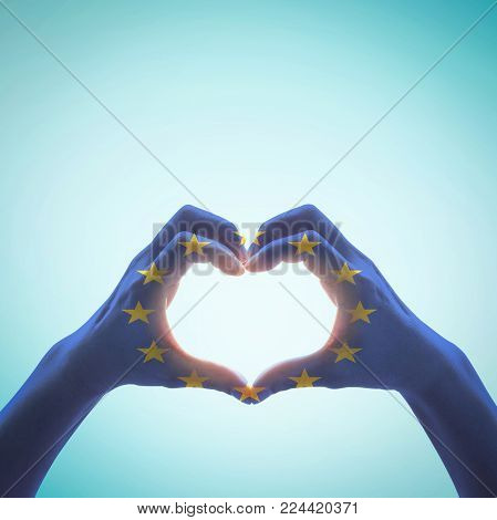 European Union Flag Pattern On People Hands In Heart Shape On Blue Sky
