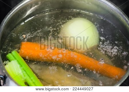 cooking soup - boiling meat broth in steel stewpan close up