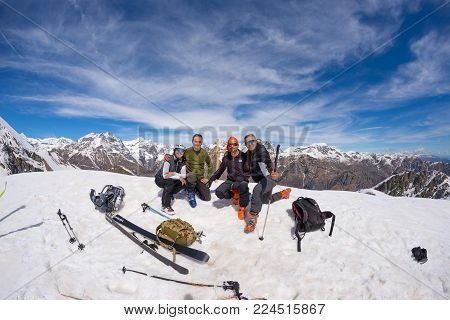 Group Of Alpinists Selfie On Mountain Top. Scenic High Altitude Background On Snow Capped Alps, Sunn
