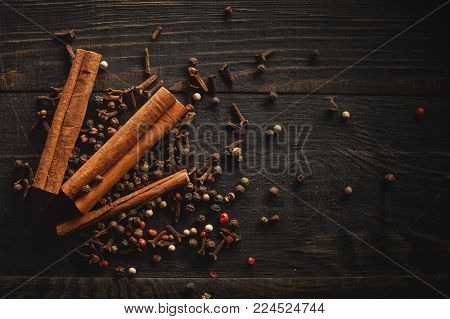 Spices and canella on the black wood background. Food and cuisine ingredients.