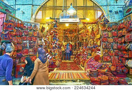 SHIRAZ, IRAN - OCTOBER 12, 2017: The large showcase of the carpet store in Vakil Bazaar with wide range of bags, decorated with woven details, on October 12 in Shiraz.
