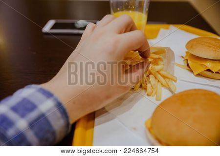 man eat french fries in cafe first person view