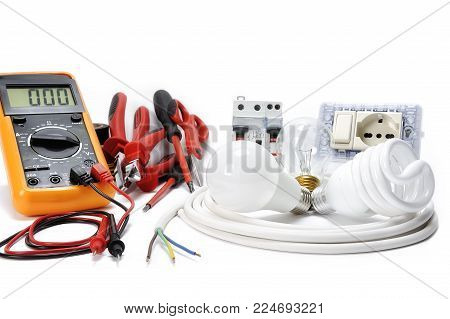 Multimeter, work tools and components for a residential electrical installation, photographed on a white background.