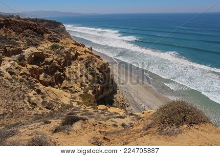 LaJolla, California, USA- August 27, 2014 - Looking down from the impressive bluffs high above the Torrey Pine State Beach to the wide, sandy beach and crashing surf below on a sunny summer day.