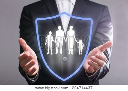 Close-up Of A Businessperson's Hand With Shield Protecting Family