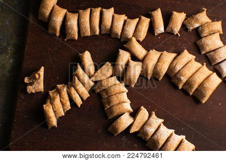 Sliced dough pieces for pasta on the board top view horizontal