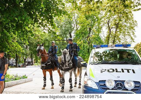 Oslo, Norway-August 13, 2014 -The  mounted police at the Norwegian parliament building and demonstration during a protest, Stortinget.