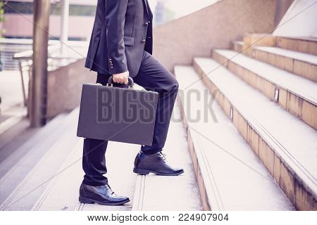 Business people walking on street in the city,Business street in big city.After office work.In front of corporate building.Businessman walking quick steps 