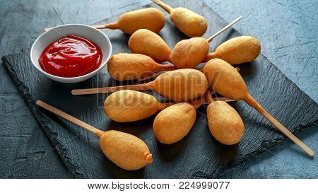 Mini Corn Dogs on stone platter with ketchup.