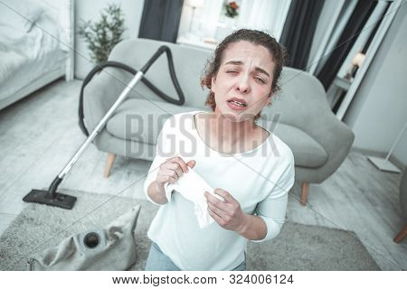 Curly Woman Sneezing In Living Room Having Allergy To Dust