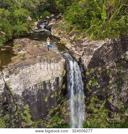 Active Sporty Woman Relaxing In Nature, Practicing Yoga On High Clif By 500 Feet Waterfall At Black 