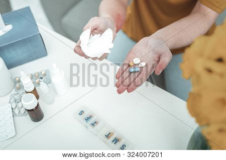 Woman Holding Pills In Her Palm While Suffering From Allergy