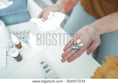 Woman Holding Pills And Napkin While Suffering From Allergy