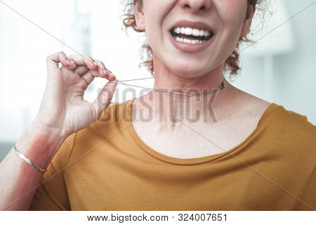 Close Up Of Woman With Rash On Her Neck Taking Necklace Away
