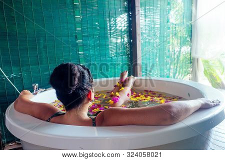 Naked Brunette Young Woman Relaxing In Bath With Petals In Tropics. Time For Yourself.romantic 14 Fe
