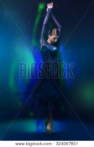 Beautiful girl performs Latino dance with expression. Professional dancer in motion. Beauty, fashion.